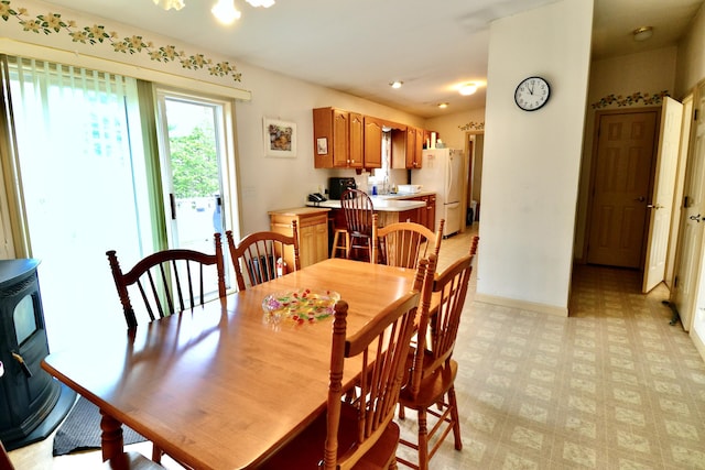 62 Jernegan Ave, Edgartown, MA 02539 - dining area featuring light floors, a wood stove, and baseboards