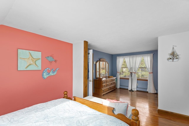 bedroom featuring a baseboard heating unit and dark hardwood / wood-style flooring