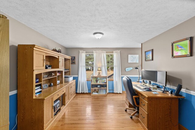 office space featuring a textured ceiling and light hardwood / wood-style flooring