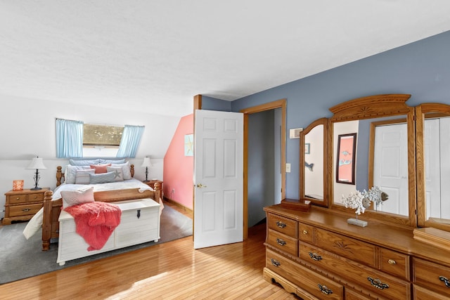 bedroom featuring vaulted ceiling and light hardwood / wood-style flooring