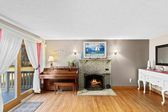 living area with hardwood / wood-style flooring, a textured ceiling, and a fireplace