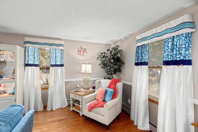 living area featuring a baseboard radiator and hardwood / wood-style floors