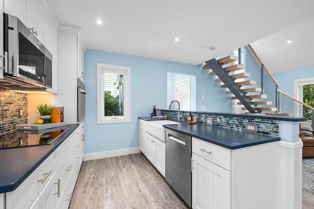 290 Fletcher Ln, Brewster, MA 02631 - kitchen featuring appliances with stainless steel finishes, a peninsula, dark countertops, tasteful backsplash, and recessed lighting