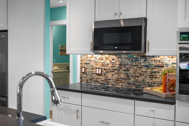 290 Fletcher Ln, Brewster, MA 02631 - kitchen featuring stainless steel appliances, dark countertops, white cabinets, and backsplash