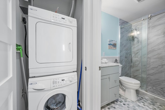 290 Fletcher Ln, Brewster, MA 02631 - washroom featuring stacked washer and clothes dryer, light tile patterned floors, and wainscoting