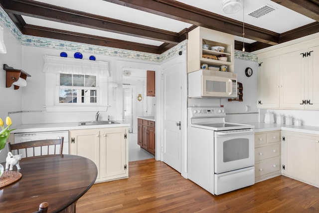 kitchen with light wood-type flooring, white appliances, a sink, and beamed ceiling