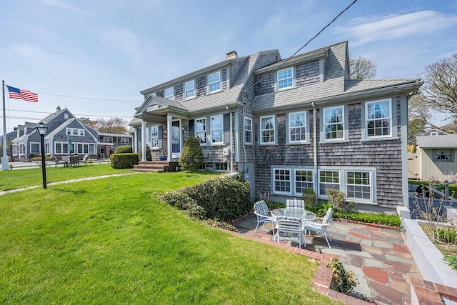 402 Old Wharf Rd, Dennis Port, MA 02639 - back of house featuring a lawn, a patio area, roof with shingles, and a chimney