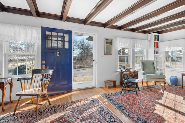 interior space with light wood finished floors, beam ceiling, and baseboards