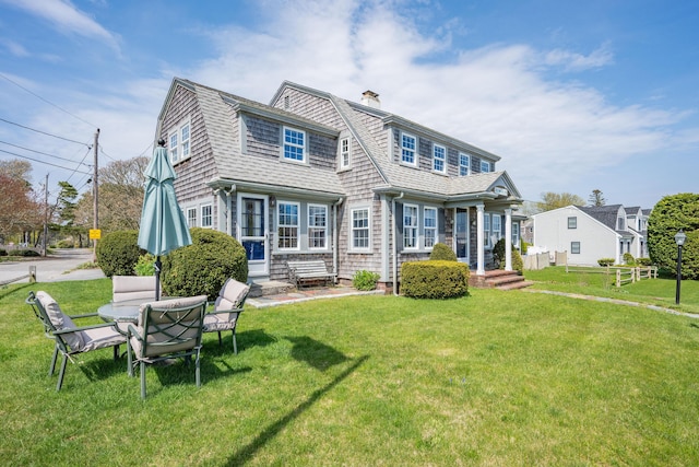 402 Old Wharf Rd, Dennis Port, MA 02639 - back of property with a yard, roof with shingles, a gambrel roof, and a chimney