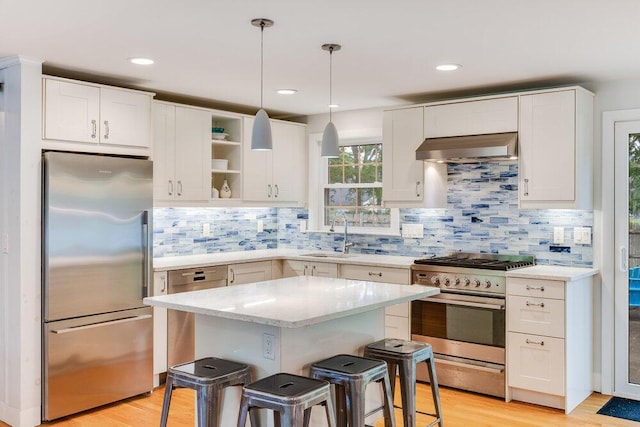 22 Emerson Rd, East Falmouth, MA 02536 - kitchen with stainless steel appliances, wall chimney range hood, open shelves, white cabinetry, and a center island