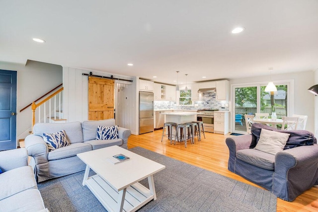 22 Emerson Rd, East Falmouth, MA 02536 - living room featuring light wood finished floors, a barn door, recessed lighting, and stairs