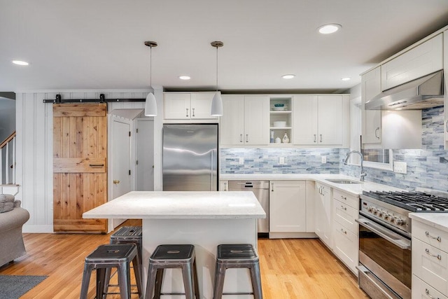 22 Emerson Rd, East Falmouth, MA 02536 - kitchen with stainless steel appliances, range hood, open shelves, a breakfast bar, and light wood-style flooring