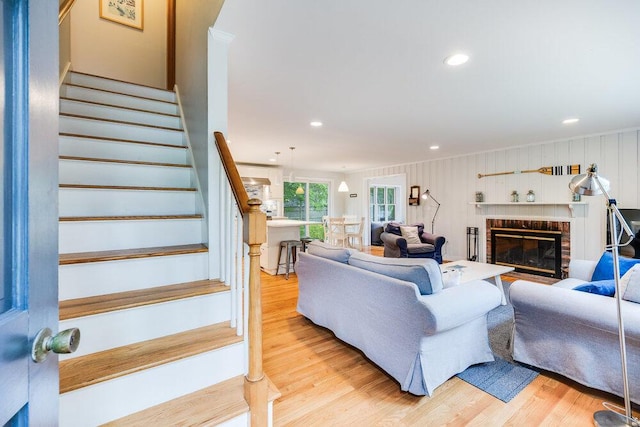 22 Emerson Rd, East Falmouth, MA 02536 - living room featuring light wood-style floors, ornamental molding, stairway, a brick fireplace, and recessed lighting