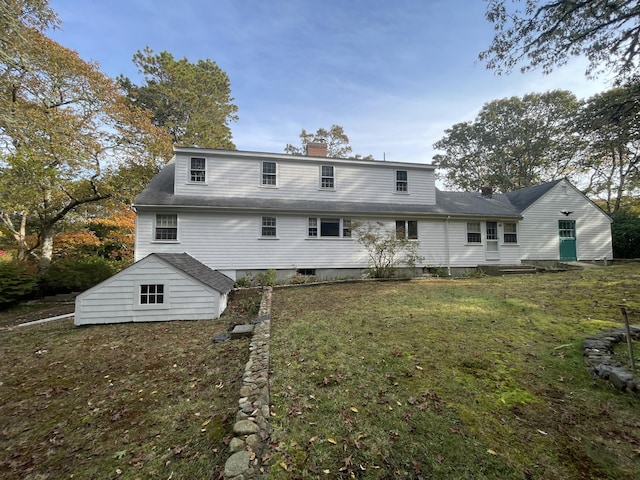 rear view of property with a lawn and a chimney