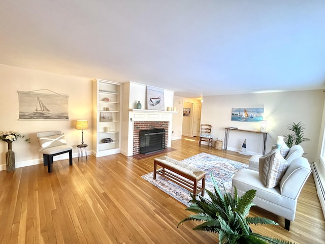 living room with hardwood / wood-style floors, a fireplace, and a baseboard radiator