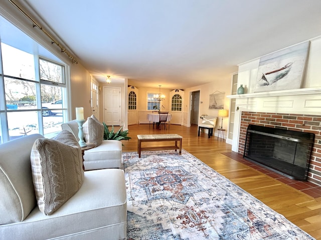 living area with a chandelier, wood finished floors, and a fireplace