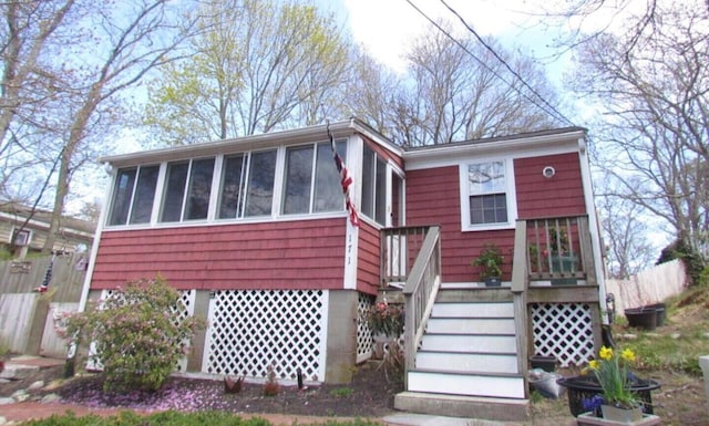 view of front of property featuring stairs and a sunroom