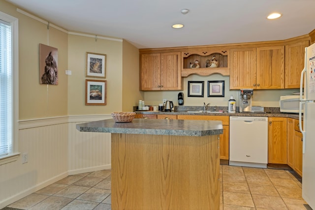110 Dillingham Ave Unit 212U, Falmouth, MA 02540 - kitchen with white appliances, a kitchen island, dark countertops, light tile patterned floors, and a wainscoted wall