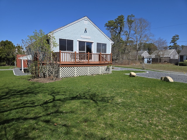 rear view of property with a wooden deck and a yard
