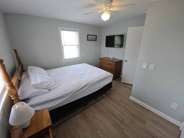 bedroom with baseboards, ceiling fan, and wood finished floors