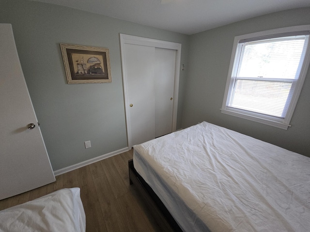 bedroom with a closet, baseboards, and wood finished floors