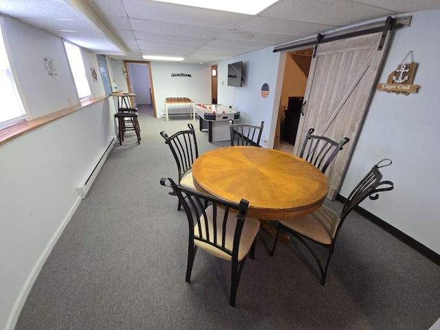 dining room with carpet floors, a baseboard radiator, a barn door, and a paneled ceiling