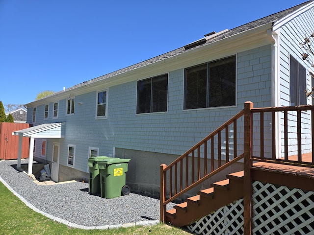 rear view of house featuring a shingled roof