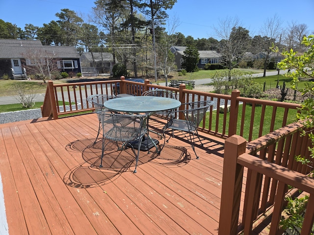 wooden deck with a yard and outdoor dining space
