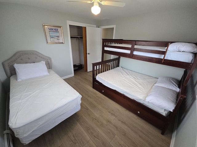 bedroom featuring ceiling fan, a closet, and wood finished floors