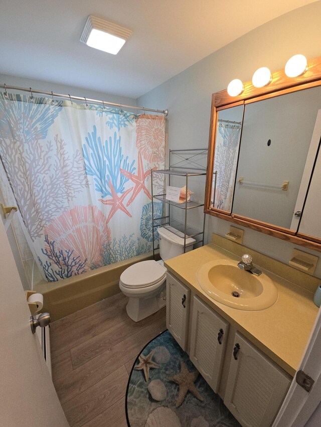 full bathroom with vanity, shower / bathtub combination with curtain, toilet, and wood finished floors