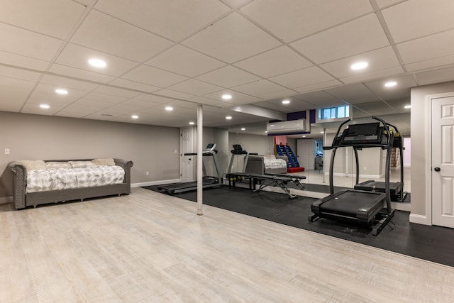 workout area with an AC wall unit and hardwood / wood-style floors