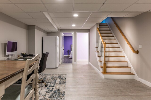 office with light hardwood / wood-style floors and a drop ceiling