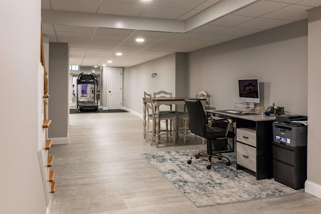 office with light hardwood / wood-style floors and a drop ceiling