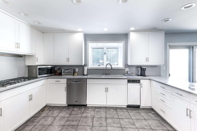 kitchen with sink, white cabinets, a healthy amount of sunlight, and appliances with stainless steel finishes