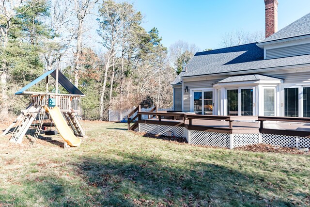 view of yard featuring a wooden deck and a playground