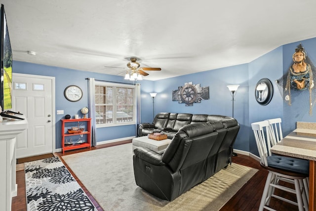 living area with ceiling fan, baseboards, and dark wood finished floors