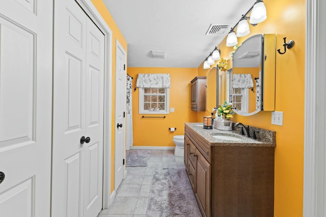 bathroom featuring tile patterned flooring, toilet, visible vents, vanity, and a closet