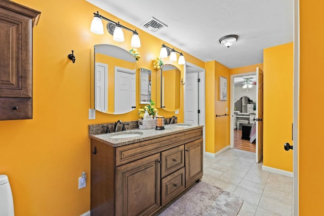 full bath featuring double vanity, tile patterned flooring, visible vents, and a sink