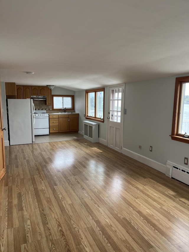 60 Academy Dr, Buzzards Bay, MA 02532 - unfurnished living room with a sink, light wood-style flooring, baseboards, radiator heating unit, and healthy amount of natural light
