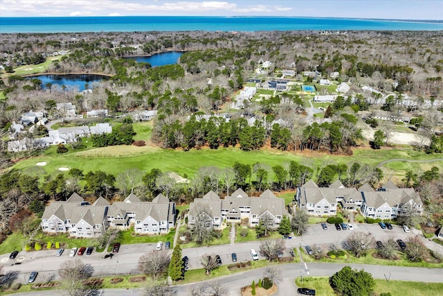 view of property location featuring nearby suburban area, a nearby body of water, and a golf club