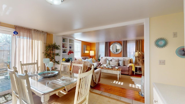 dining space with light tile patterned flooring and a healthy amount of sunlight