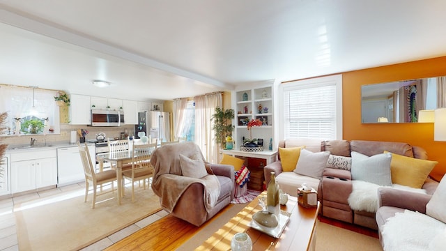 living room featuring sink and light hardwood / wood-style flooring