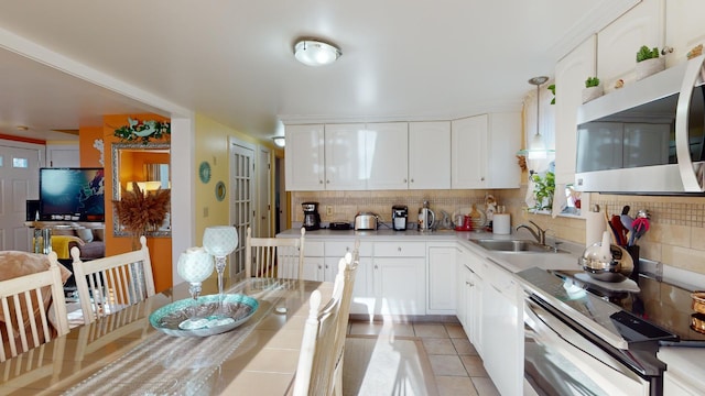 kitchen with decorative light fixtures, white cabinetry, tasteful backsplash, sink, and light tile patterned floors