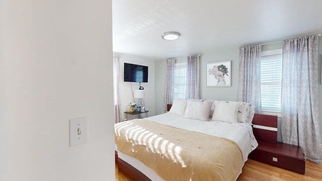 bedroom with multiple windows and light wood-type flooring