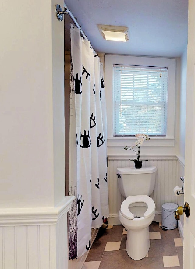 bathroom featuring toilet and a shower with curtain