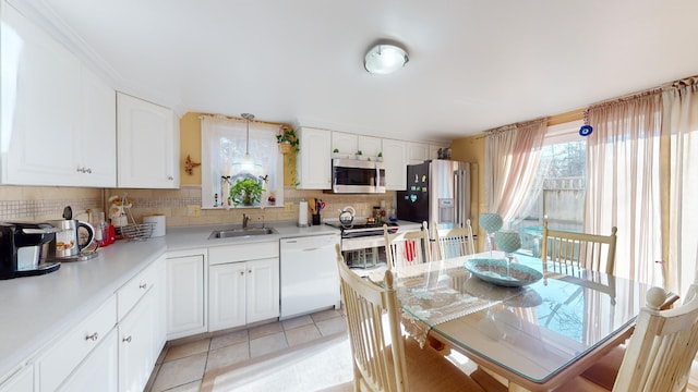 kitchen with light tile patterned floors, white cabinetry, appliances with stainless steel finishes, and sink