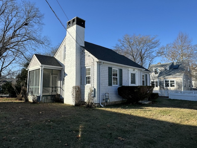 view of side of property with a sunroom and a lawn