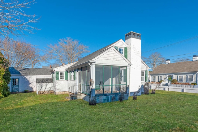 back of house featuring a yard and a sunroom