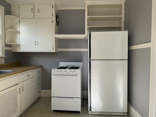 kitchen featuring white cabinets, refrigerator, and gas range gas stove