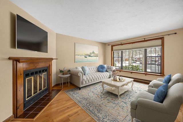 living room with a tile fireplace, a textured ceiling, and dark hardwood / wood-style floors